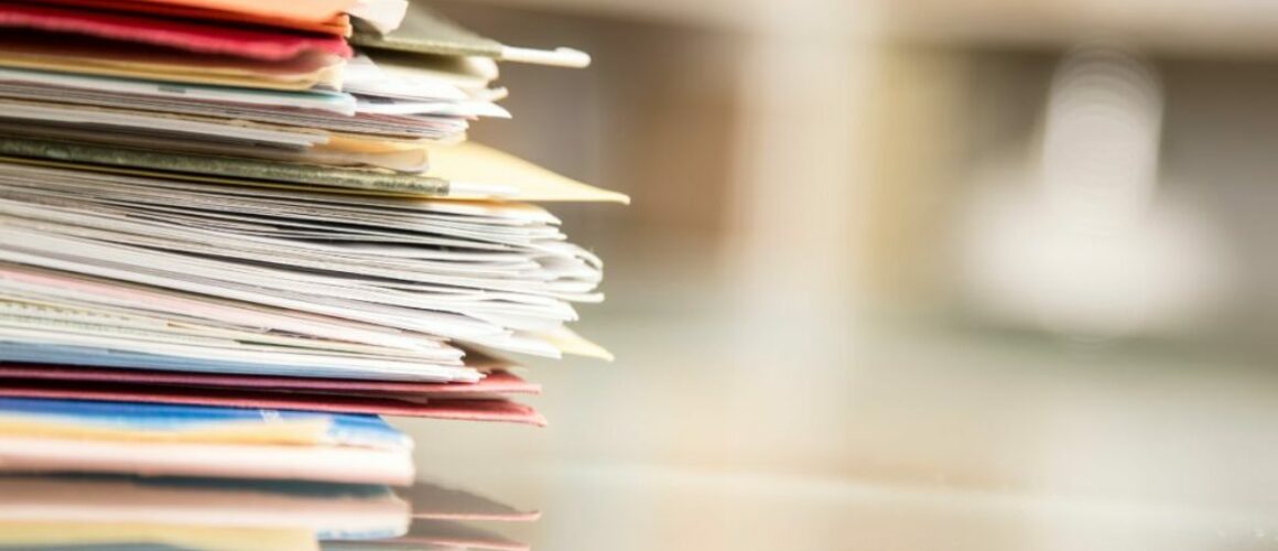 A stack of documents on a desk to help illustrate this blog on fact finding hearings.